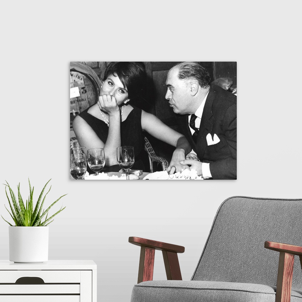 A modern room featuring Italian film actress Sophia Loren in a restaurant in France with her husband Carlo Ponti, the man...