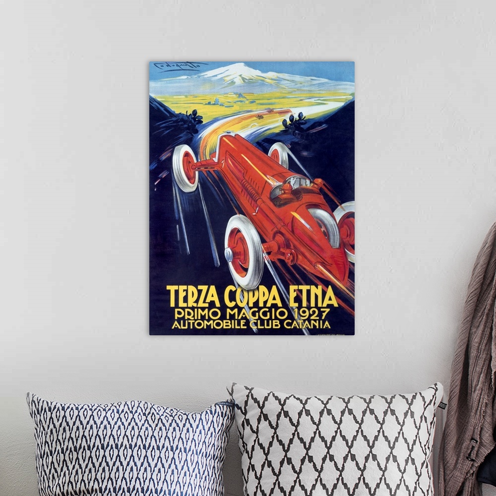 A bohemian room featuring Antique poster advertising a car club.  There is  a classic car racing through mountain roads on ...
