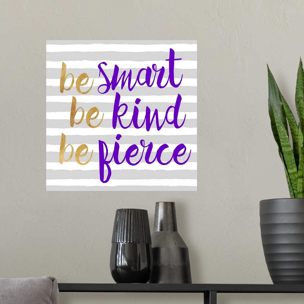 A modern room featuring "Be Smart Be Kind Be Fierce" written in purple and gold on a gray and white striped background.