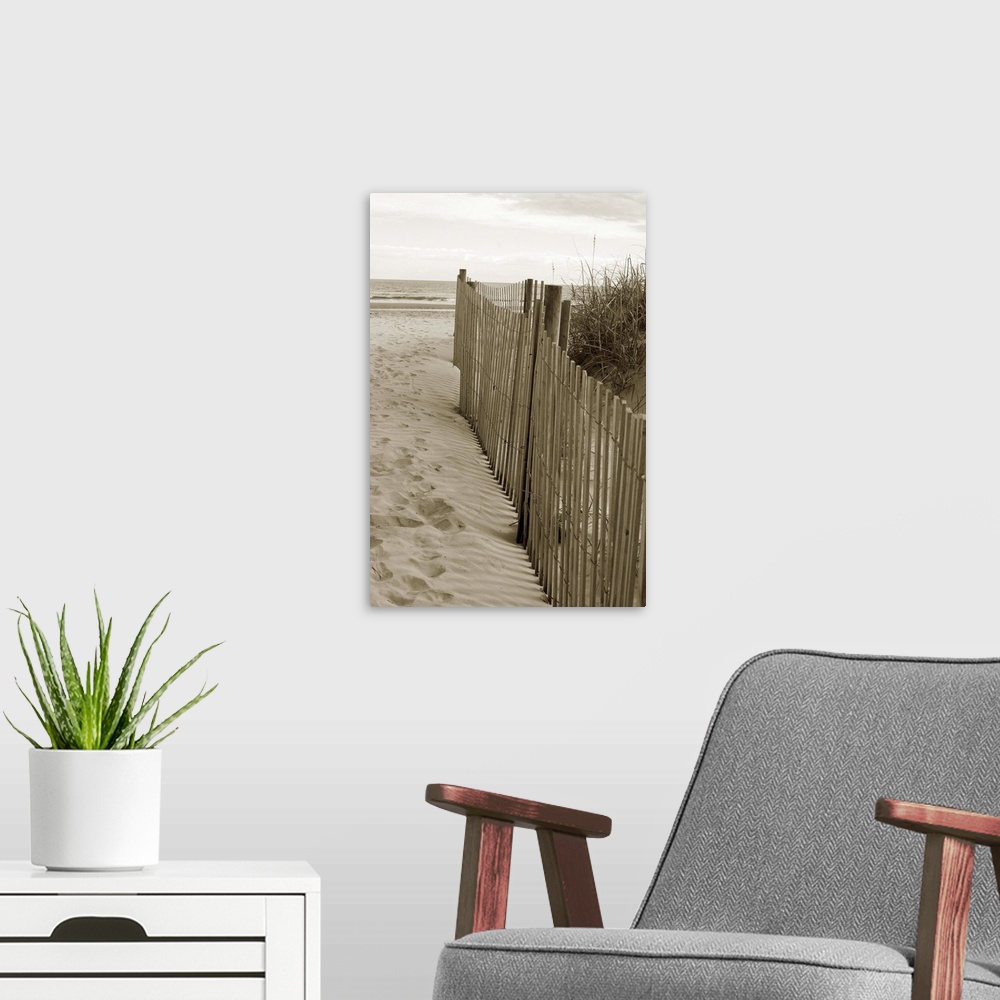 A modern room featuring Sepia toned photograph of sand dune fences making a path leading to the beach.