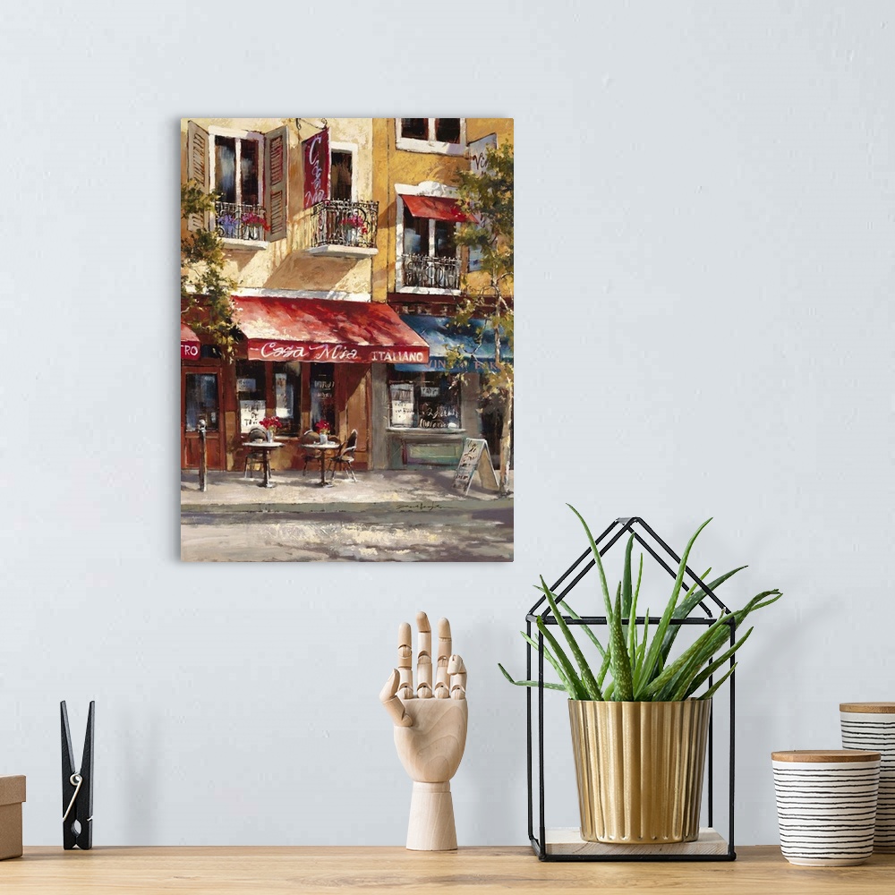 A bohemian room featuring Contemporary painting of a cafe alongside colorful buildings.