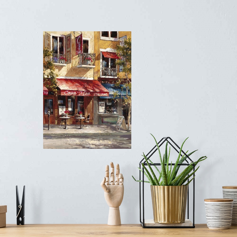 A bohemian room featuring Contemporary painting of a cafe alongside colorful buildings.