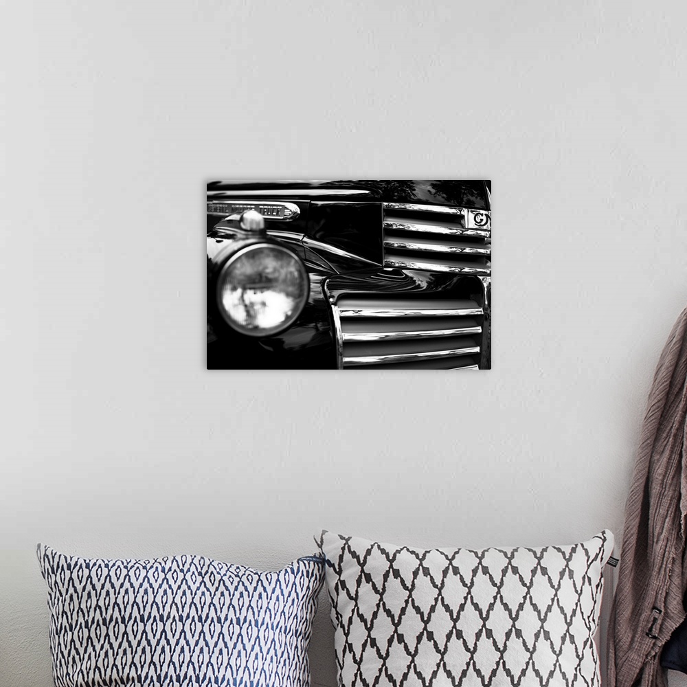 A bohemian room featuring Black and white photo of the headlight and grille of a classic car.