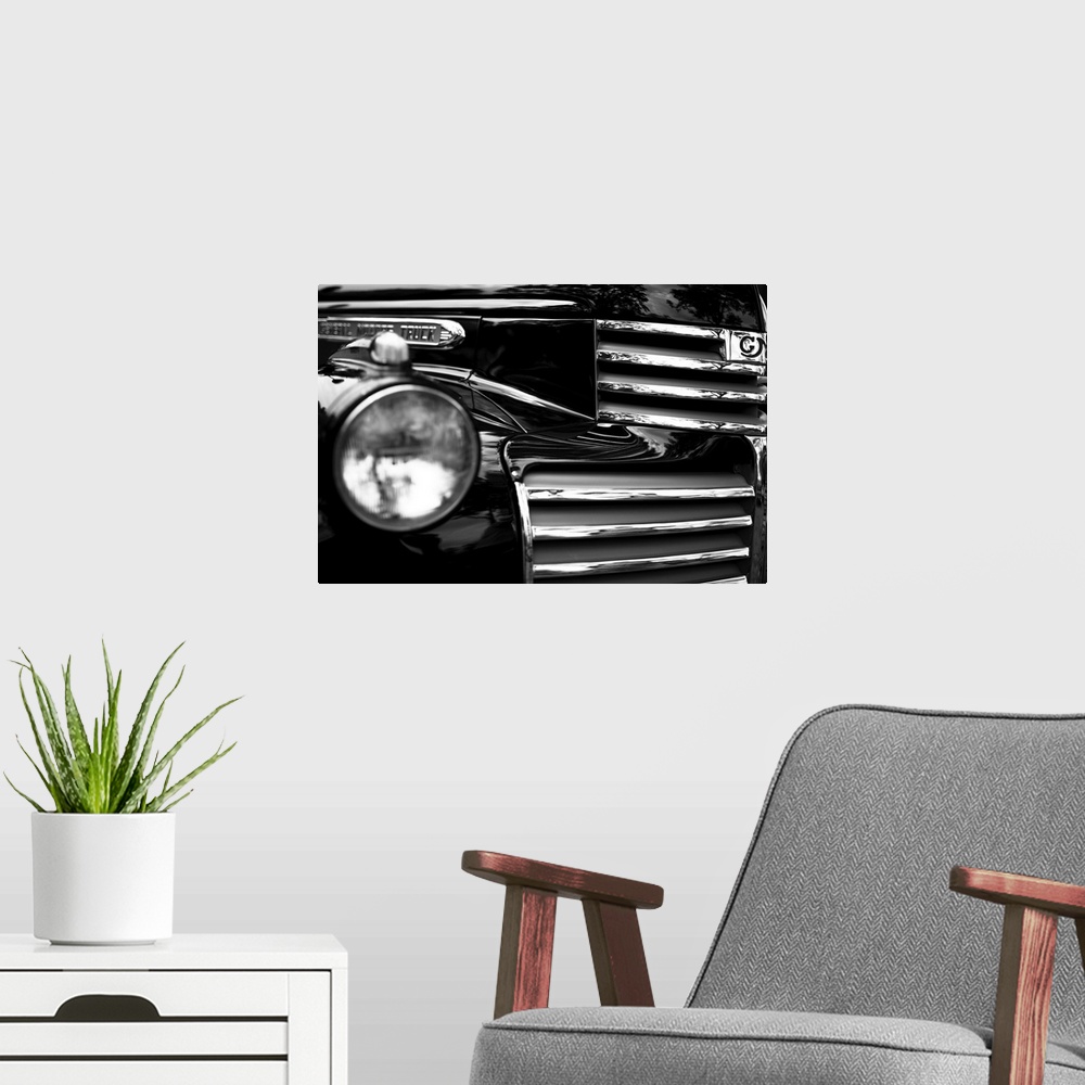 A modern room featuring Black and white photo of the headlight and grille of a classic car.