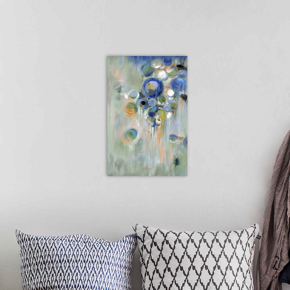 A bohemian room featuring Home decor abstract artwork of blue circles of different sizes against a pale green background.