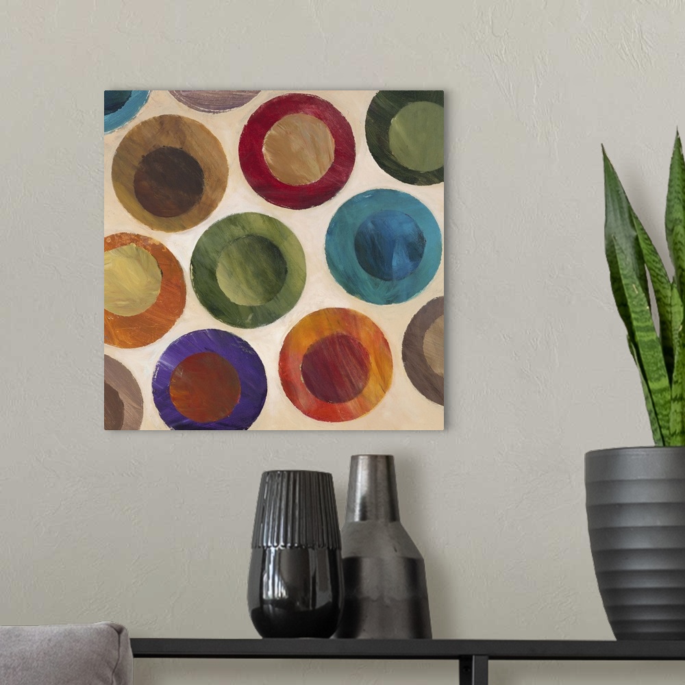 A modern room featuring Contemporary abstract painting of multi-colored circles against a beige background.