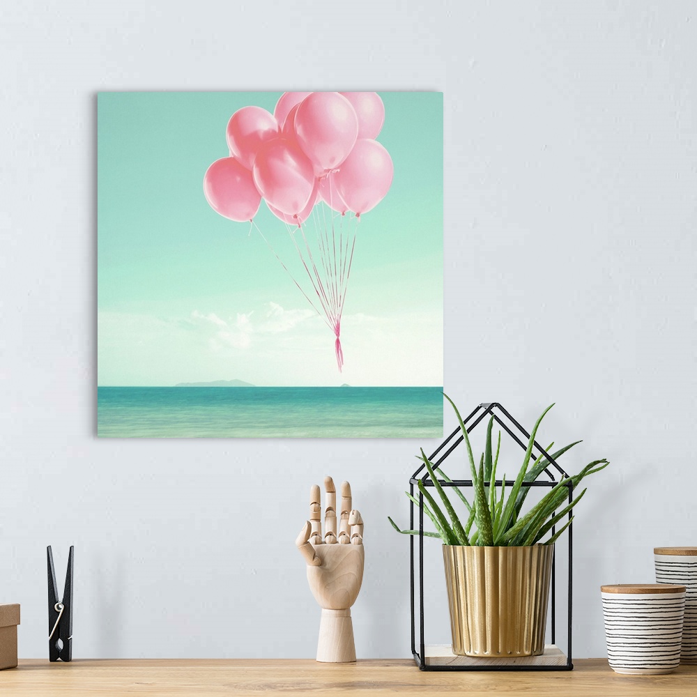 A bohemian room featuring Pink balloons floating over the ocean on a square background.