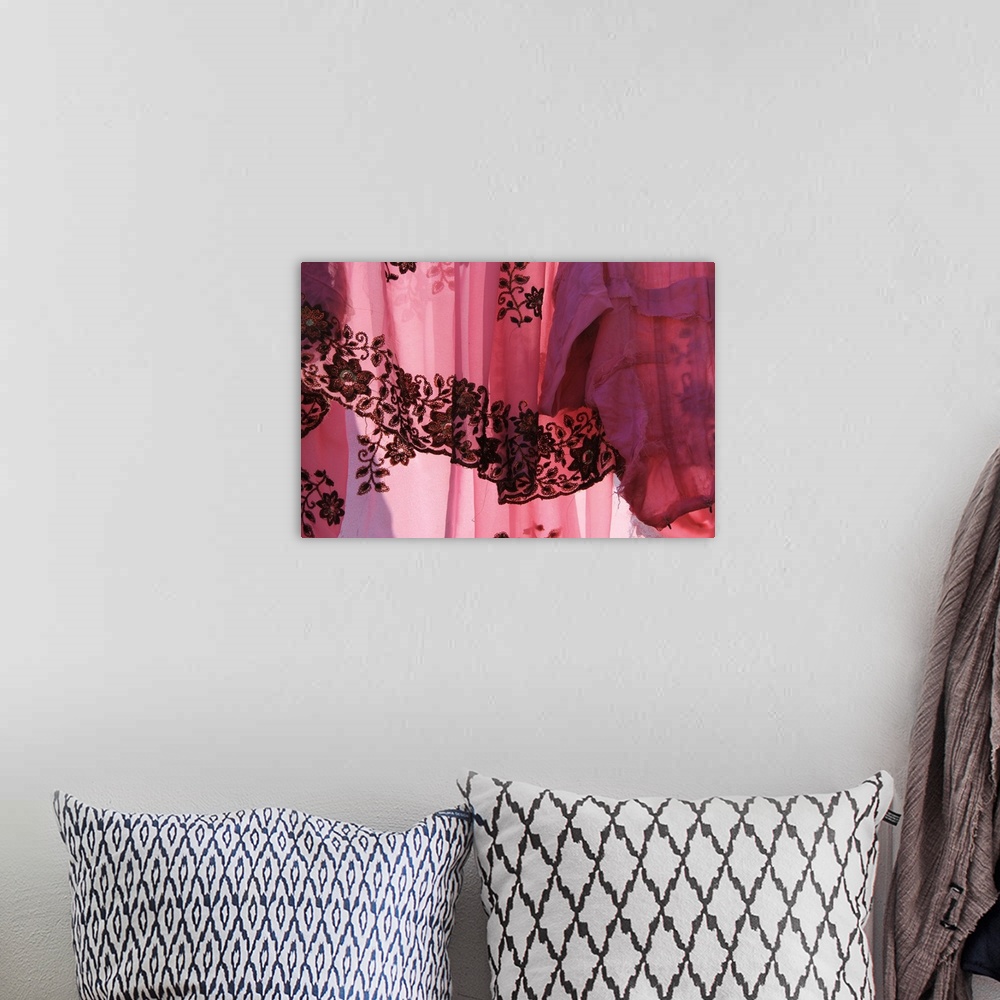 A bohemian room featuring Photograph of a sheer vibrant pink fabric.