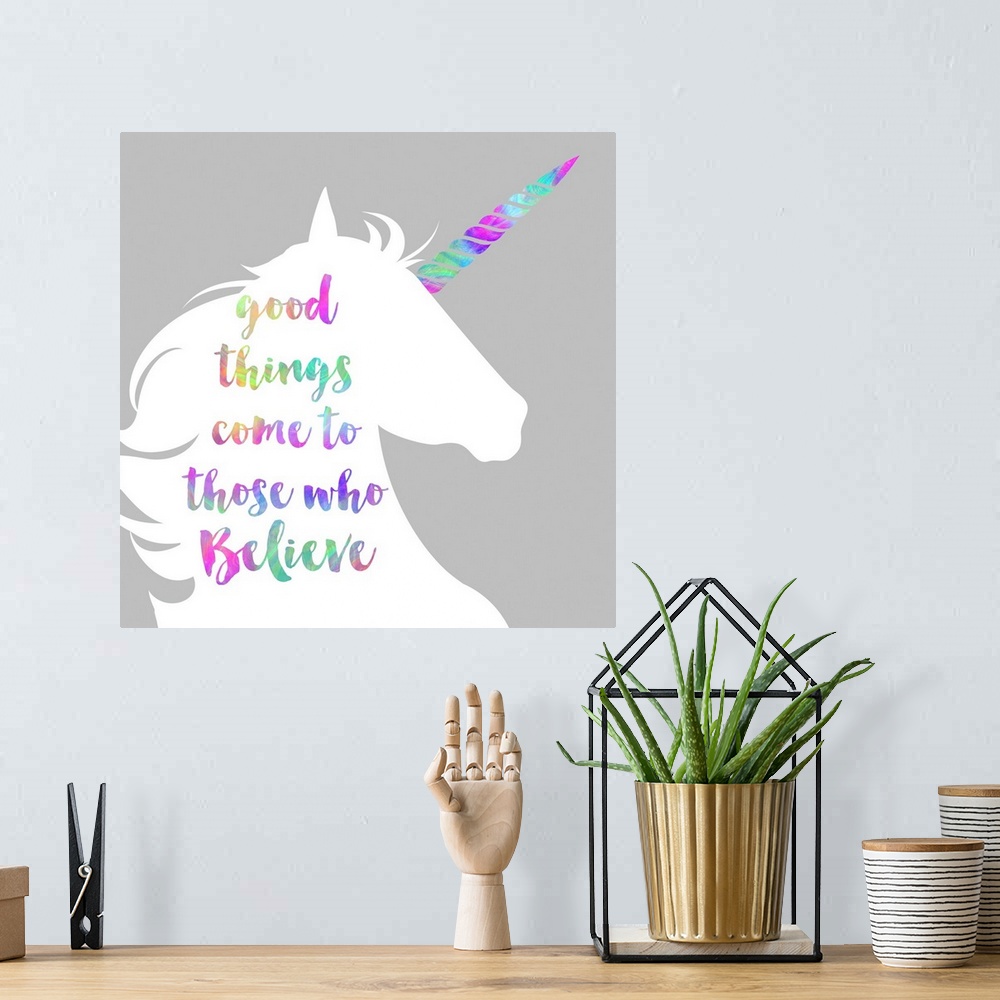A bohemian room featuring "Good Things Come to Those Who Believe" written in rainbow colors on a white unicorn silhouette.