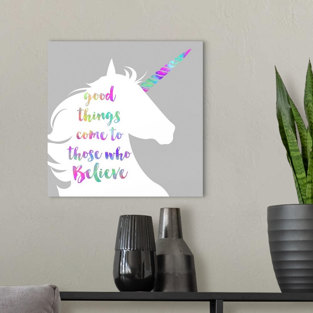 A modern room featuring "Good Things Come to Those Who Believe" written in rainbow colors on a white unicorn silhouette.