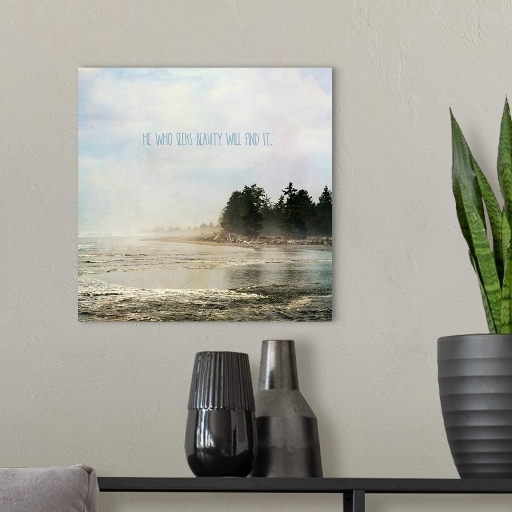 A modern room featuring "He Who Seeks Beauty Will Find It" written in blue on a square photograph of a foggy lake and shore.
