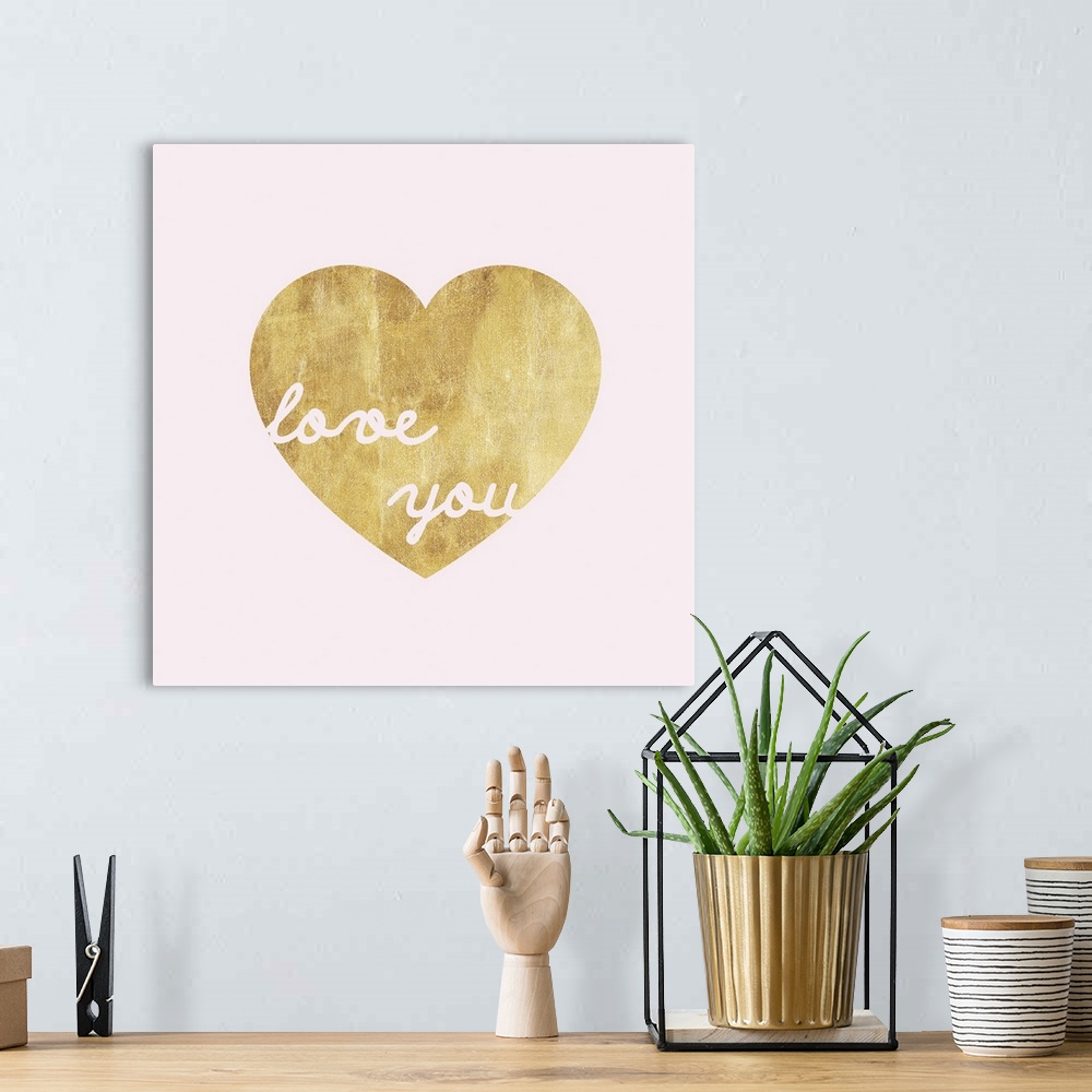 A bohemian room featuring Pink lettering inside a gold heart against a pink background.