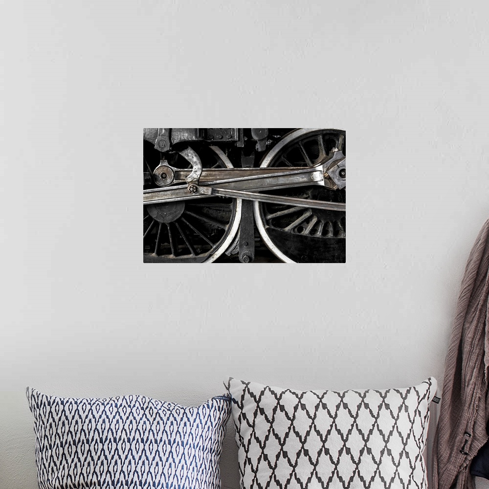 A bohemian room featuring A close-up photograph of the wheels of a train.