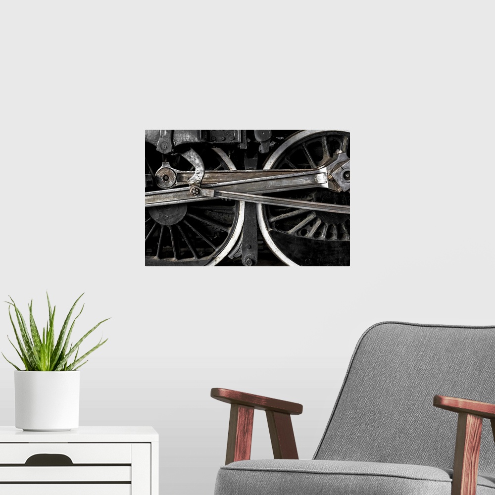A modern room featuring A close-up photograph of the wheels of a train.