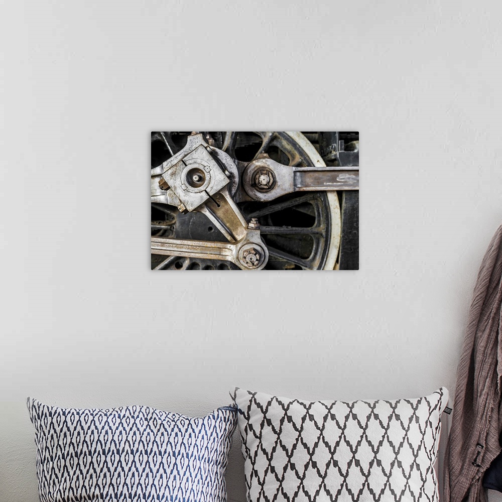 A bohemian room featuring A close-up photograph of the wheel of a train.