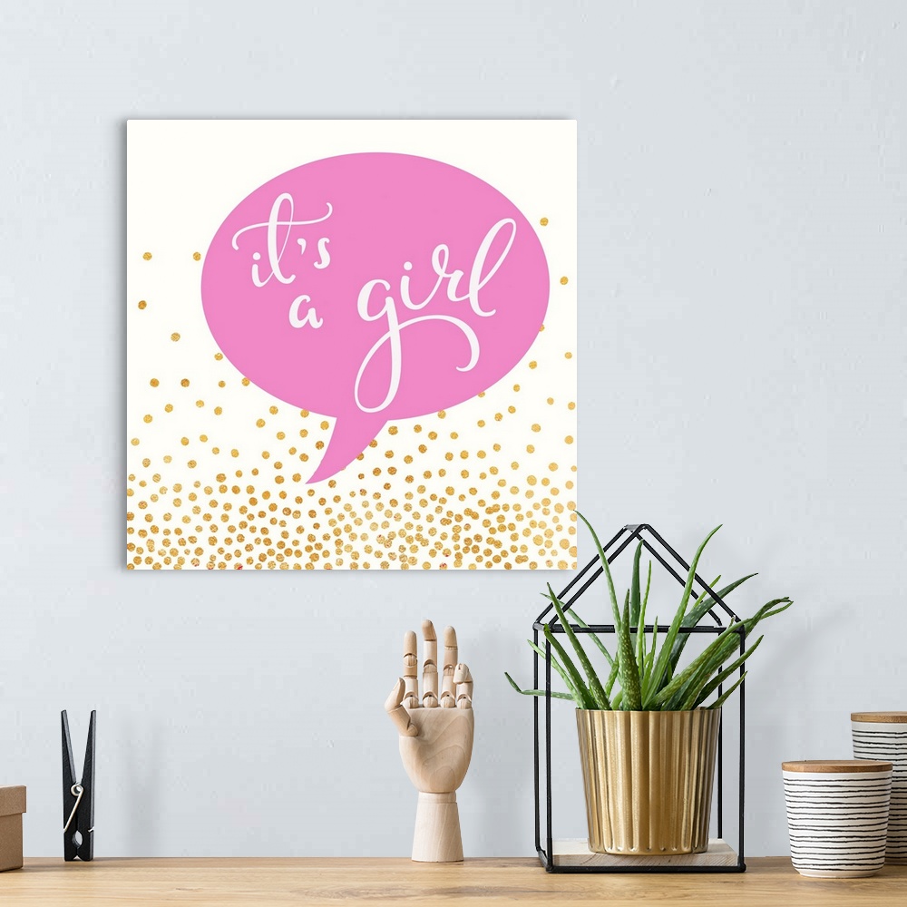 A bohemian room featuring "It's a girl" written in a pink speech balloon with gold dots.