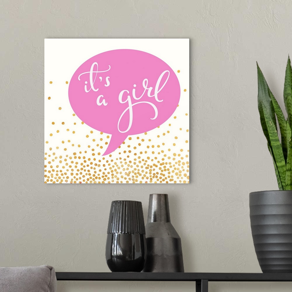 A modern room featuring "It's a girl" written in a pink speech balloon with gold dots.