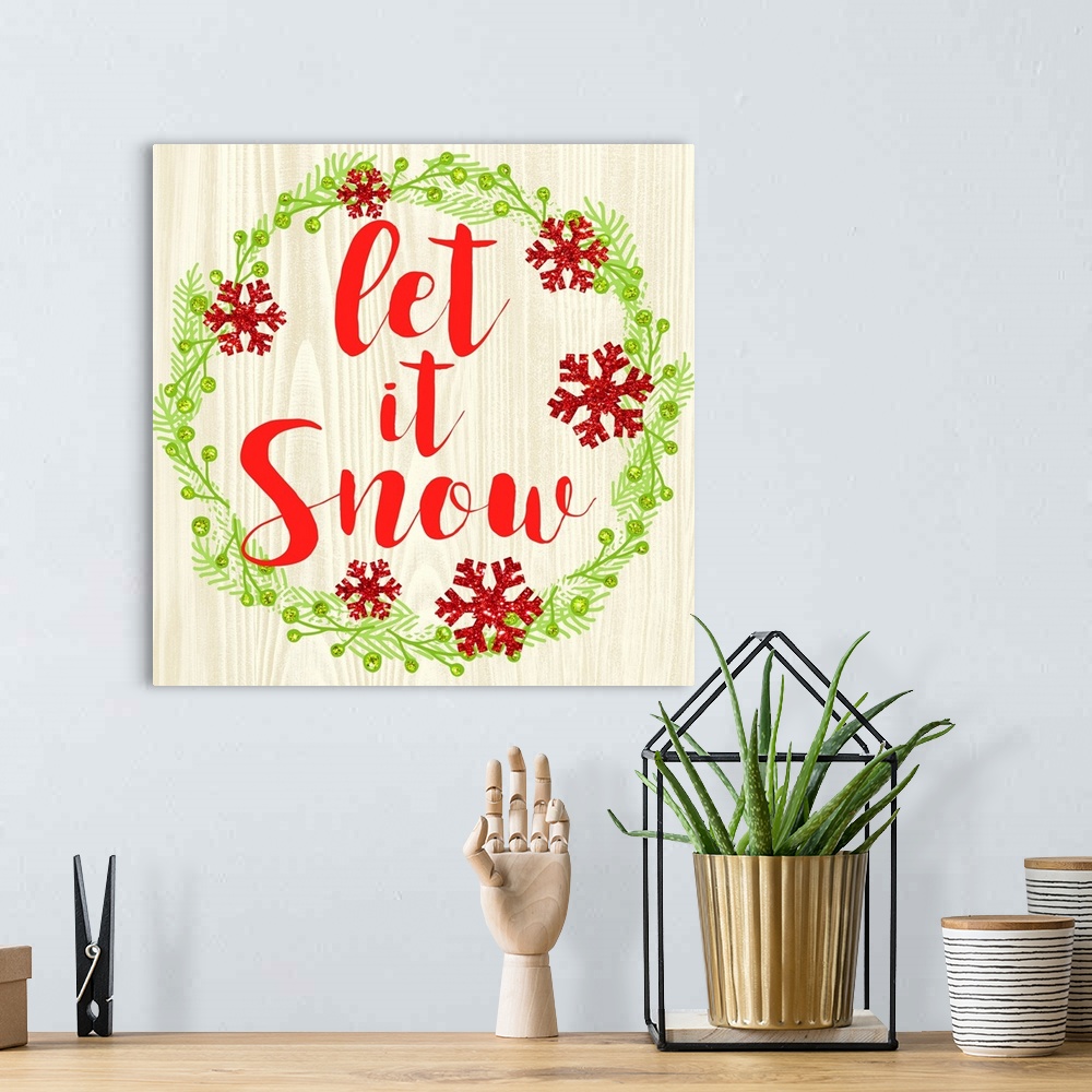 A bohemian room featuring "Let It Snow" written in red inside of a Christmas wreath on a faux wood background.