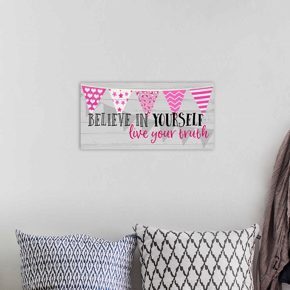 A bohemian room featuring "Believe in Yourself Lice Your Truth" written on a panel with pink decorative banners running hor...