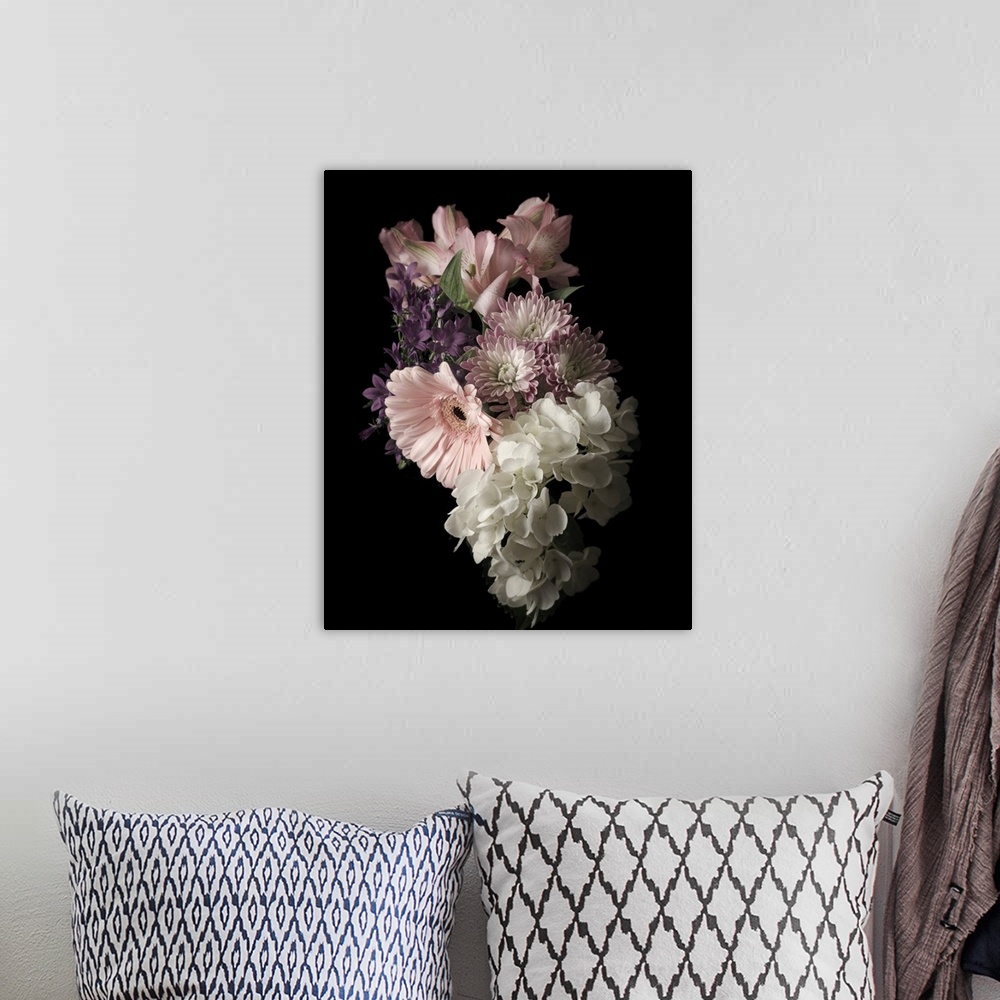 A bohemian room featuring Moody photograph of a bouquet of pastel flowers on black in low light.