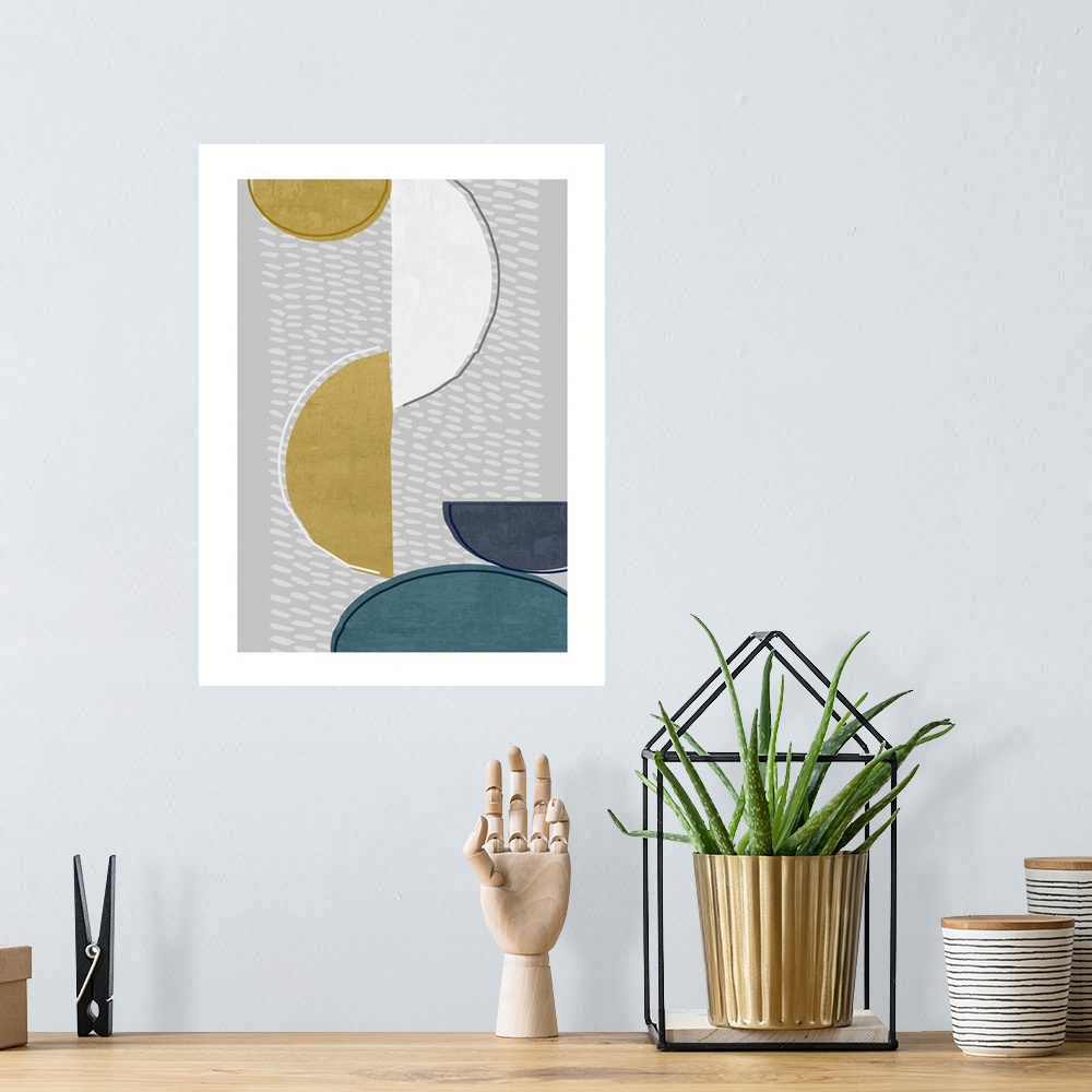 A bohemian room featuring Midcentury style abstract art of semi-circle shapes in blue, gold, and white on grey.