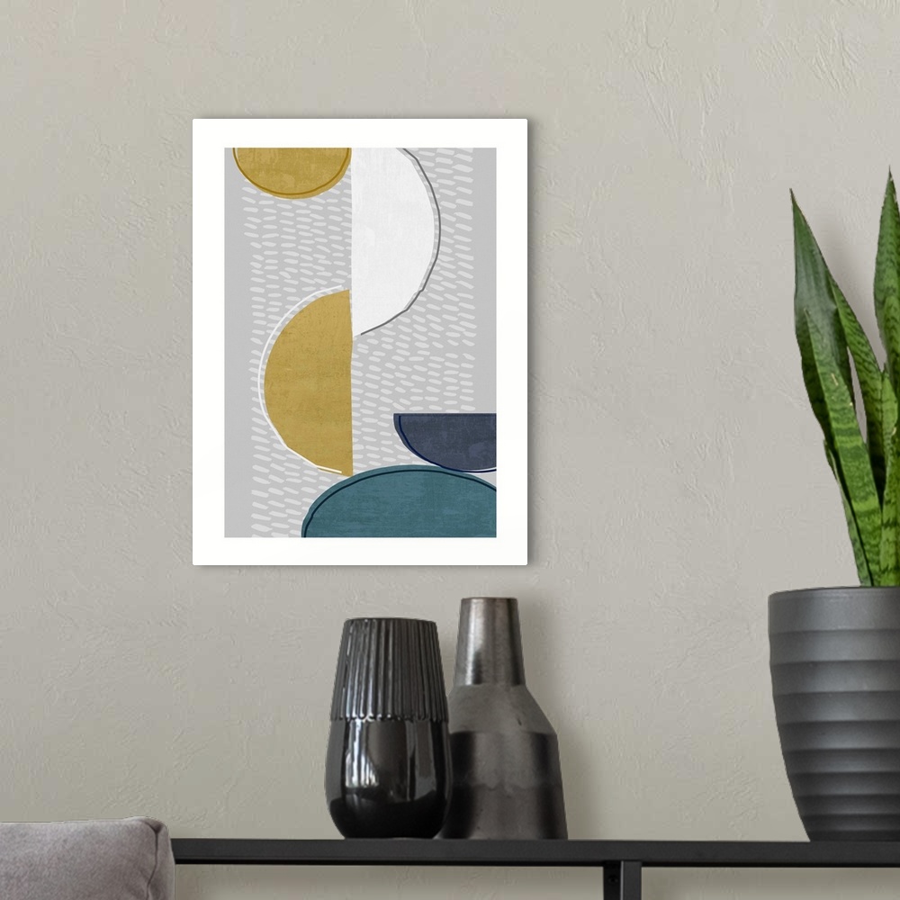 A modern room featuring Midcentury style abstract art of semi-circle shapes in blue, gold, and white on grey.