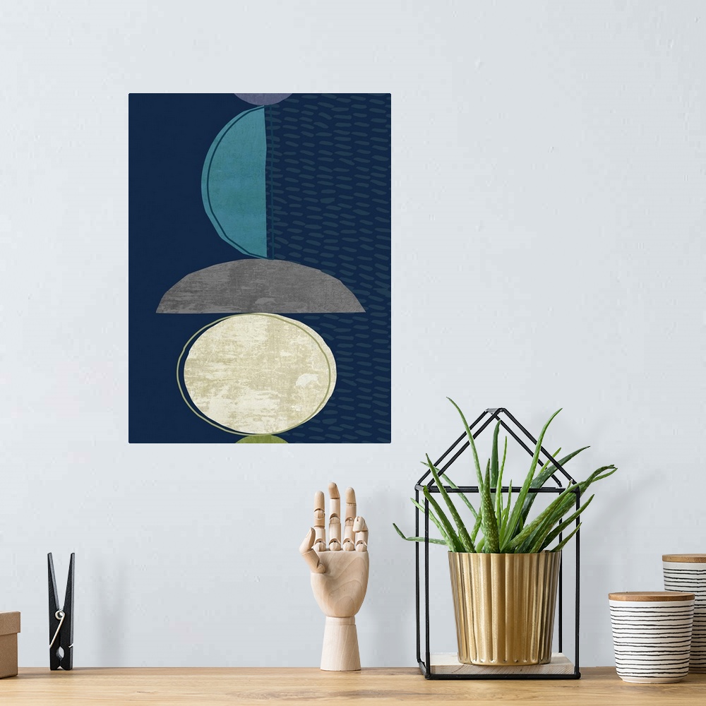 A bohemian room featuring Midcentury style abstract art of semi-circle shapes in blue, grey, and white on navy blue.