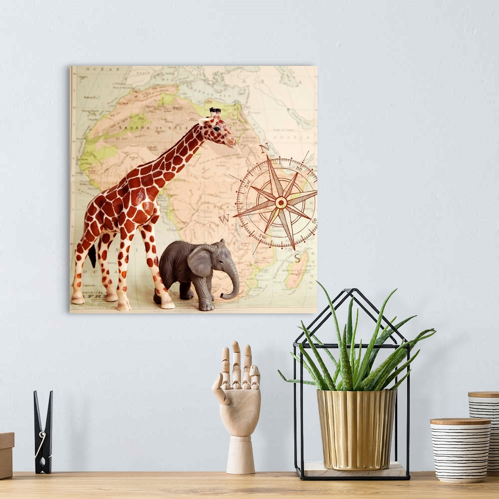 A bohemian room featuring A toy elephant and giraffe with a vintage map backdrop.