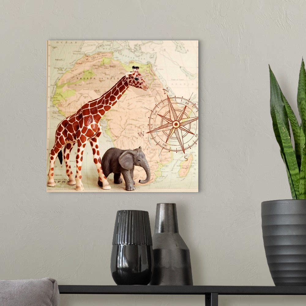 A modern room featuring A toy elephant and giraffe with a vintage map backdrop.