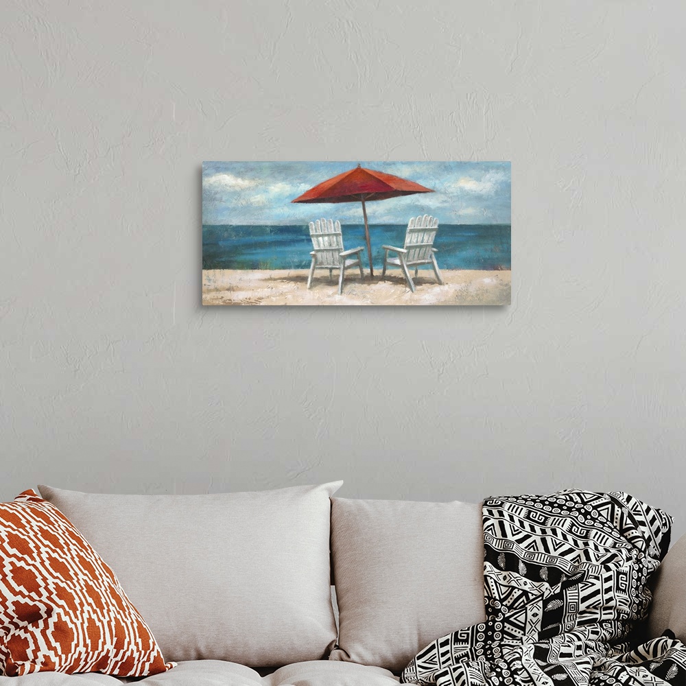 A bohemian room featuring Contemporary painting of white lounge chairs sitting under an umbrella on the beach, looking out ...