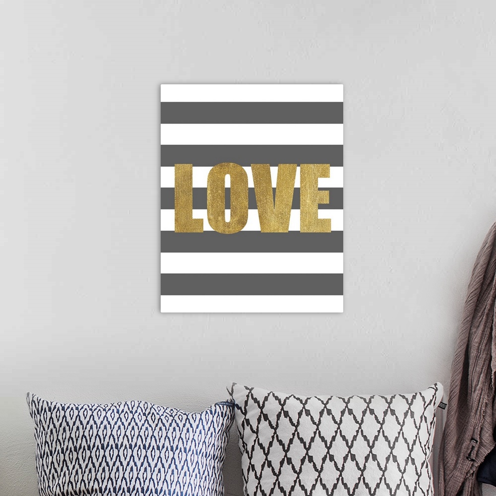 A bohemian room featuring The work Love in gold against a dark gray and white striped background.