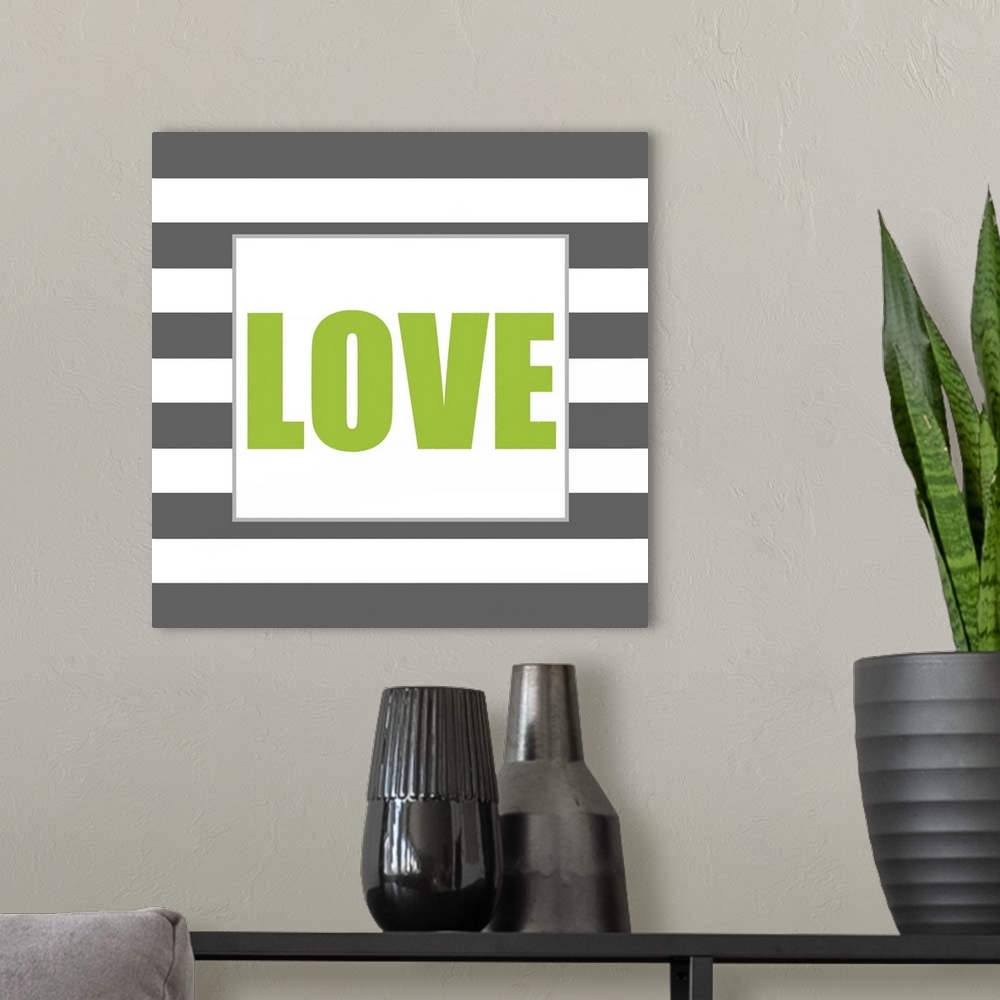 A modern room featuring The work Love in green against a dark gray and white striped background.