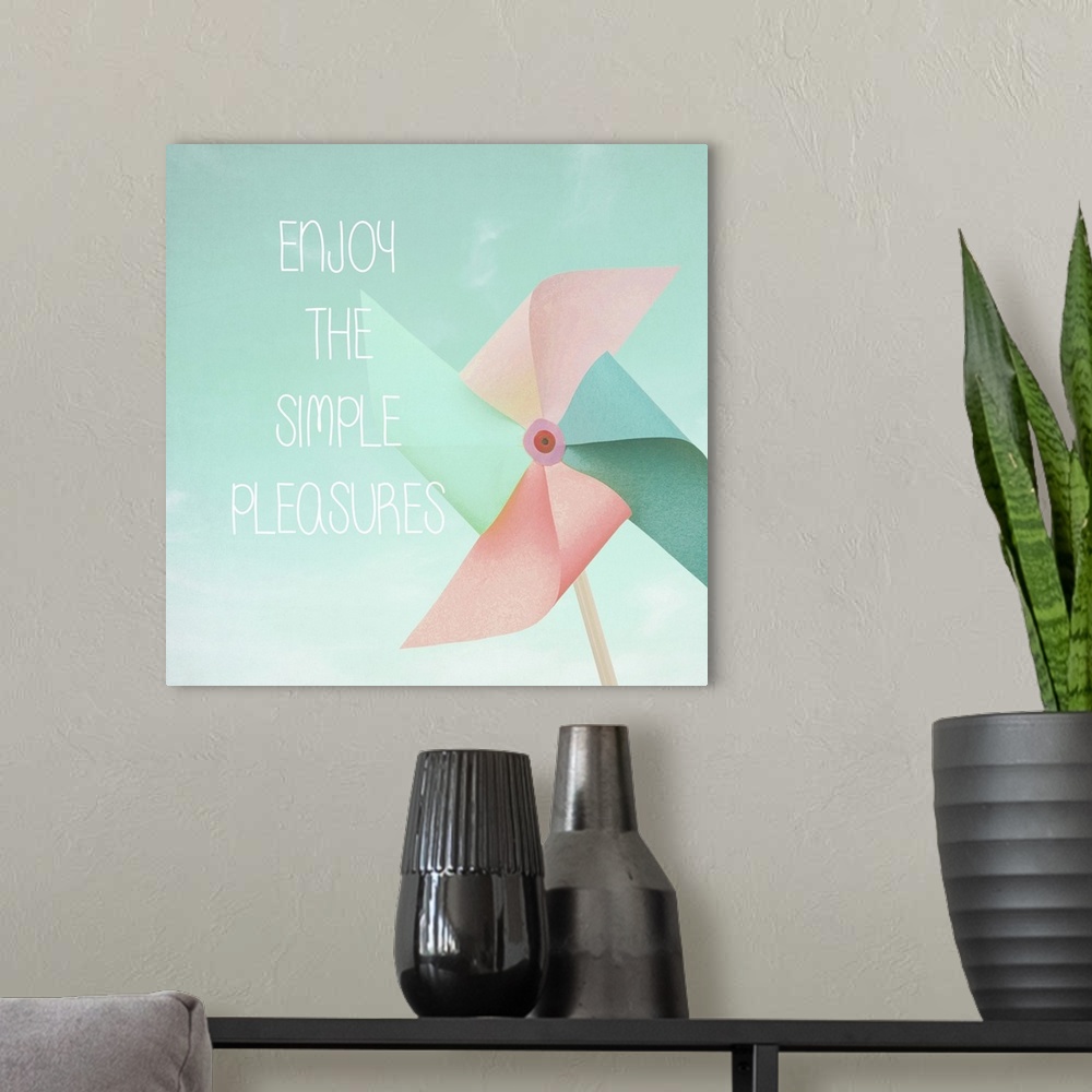 A modern room featuring "Enjoy The Simple Pleasures" written on top of a square illustration of a pastel colored pinwheel.