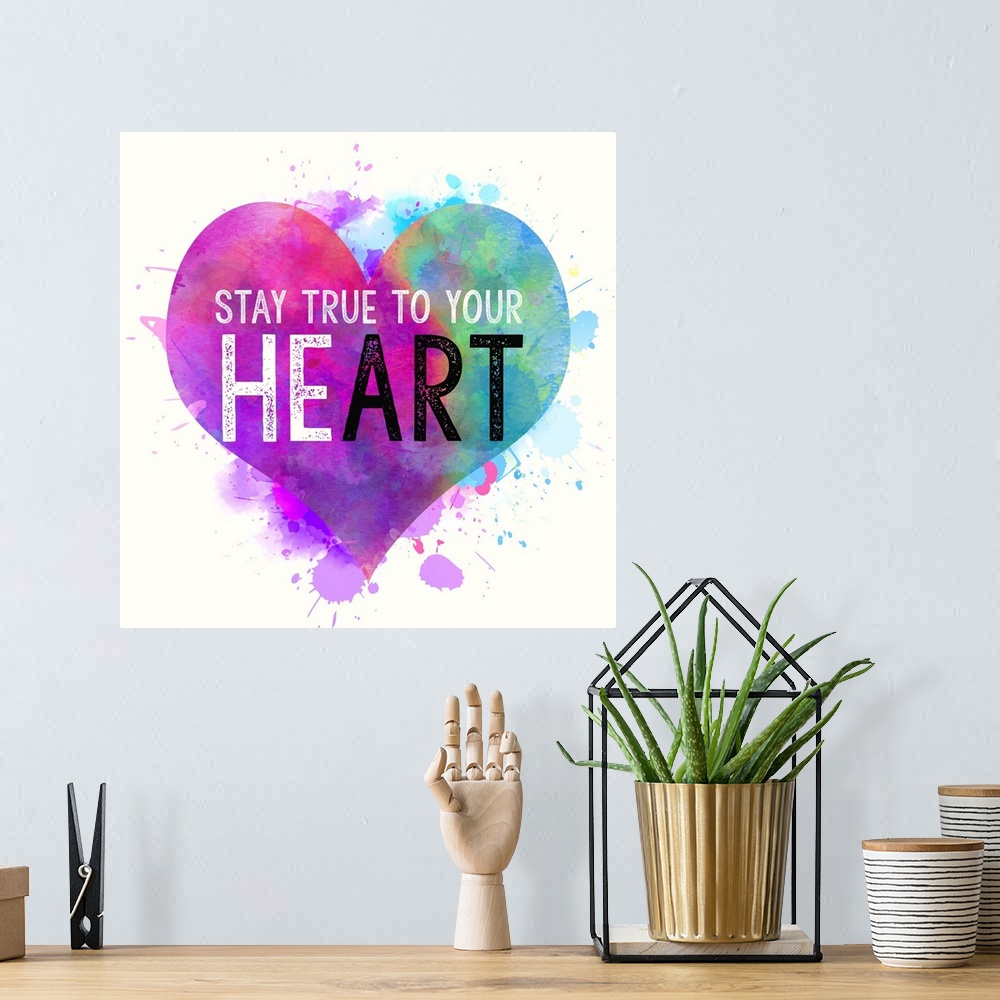 A bohemian room featuring "Stay True To Your Heart" written on top of a colorful, paint splattered heart.