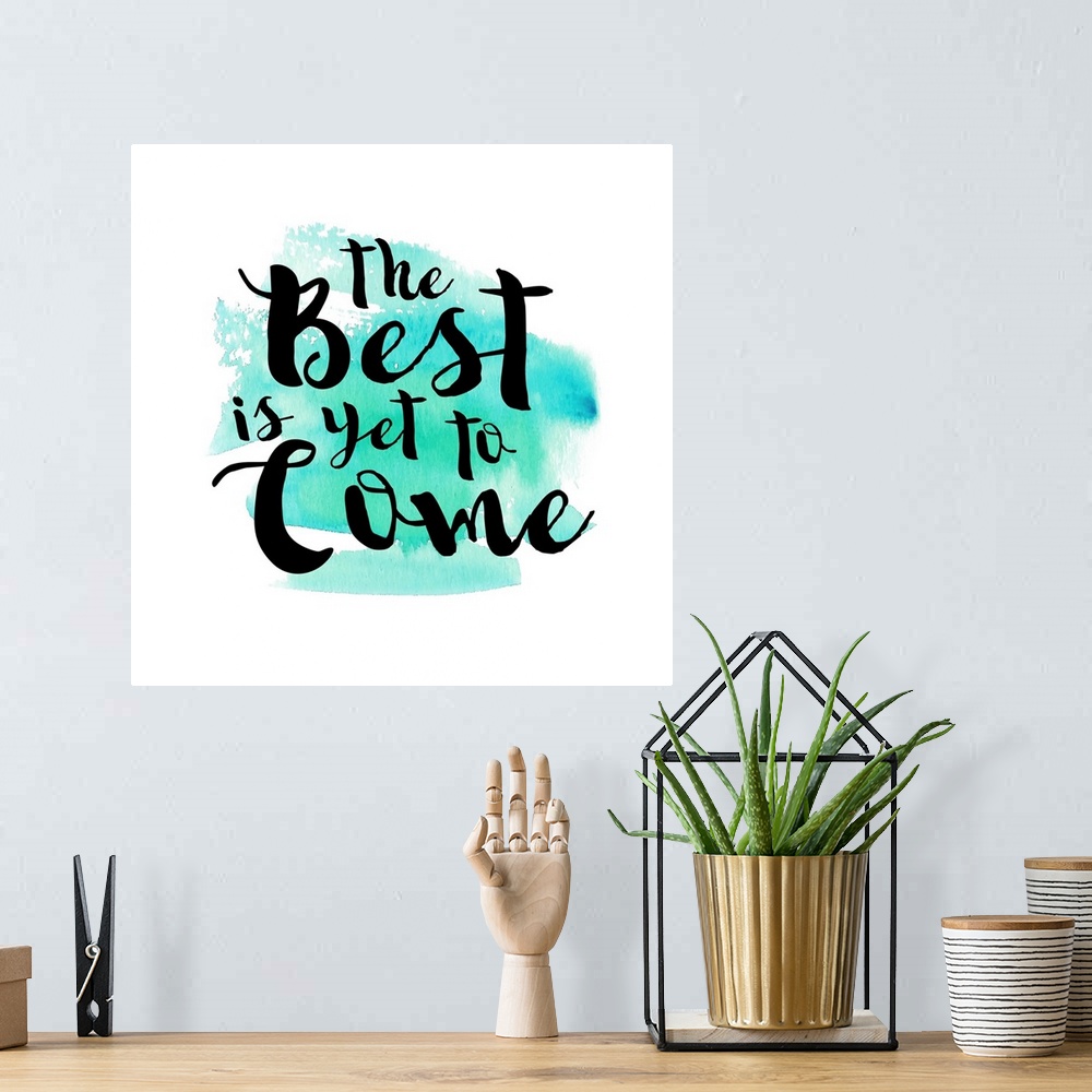 A bohemian room featuring Handlettered black text reading "The Best is yet to Come" over a teal watercolor wash.
