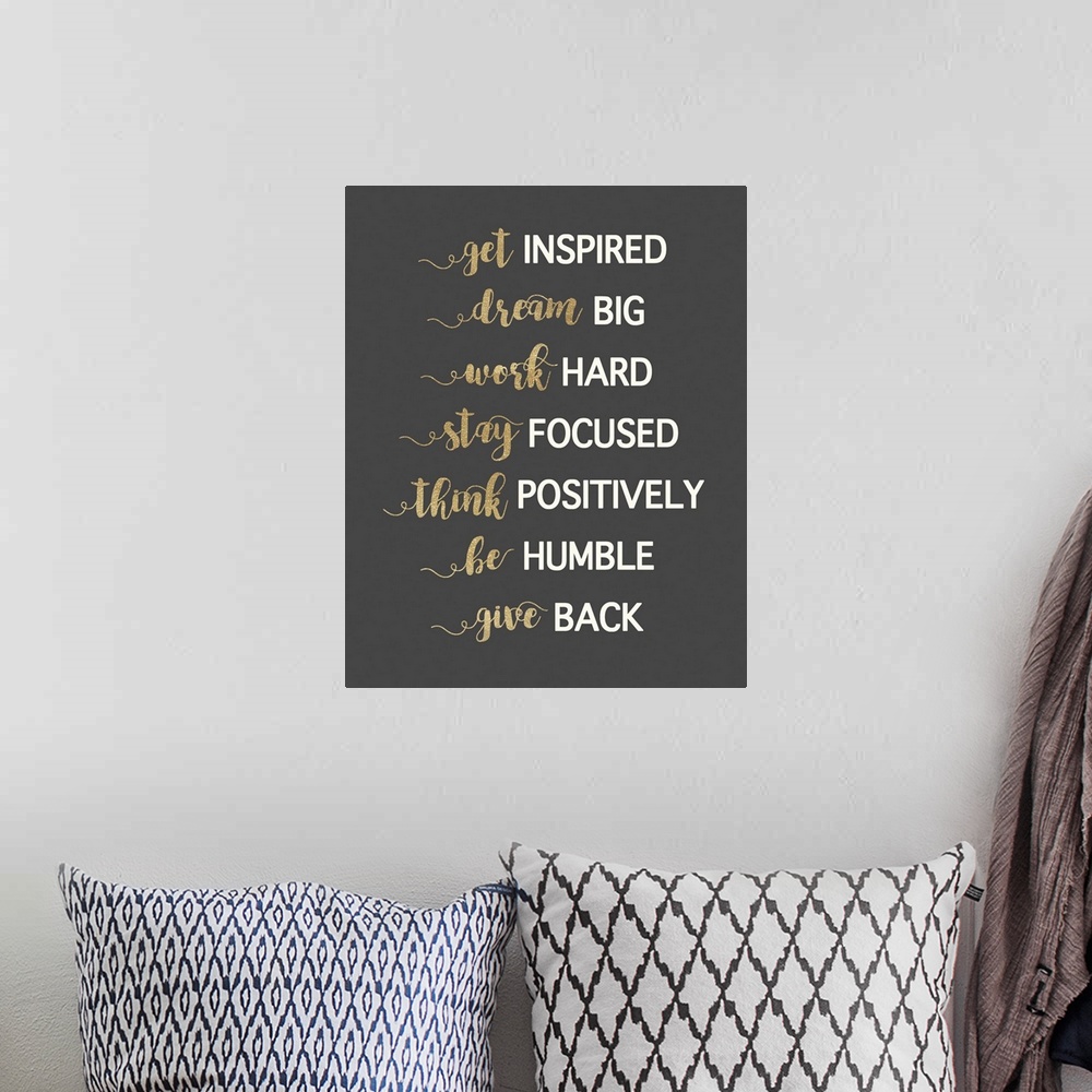 A bohemian room featuring Typography artwork in gold and white on dark grey of motivational phrases.