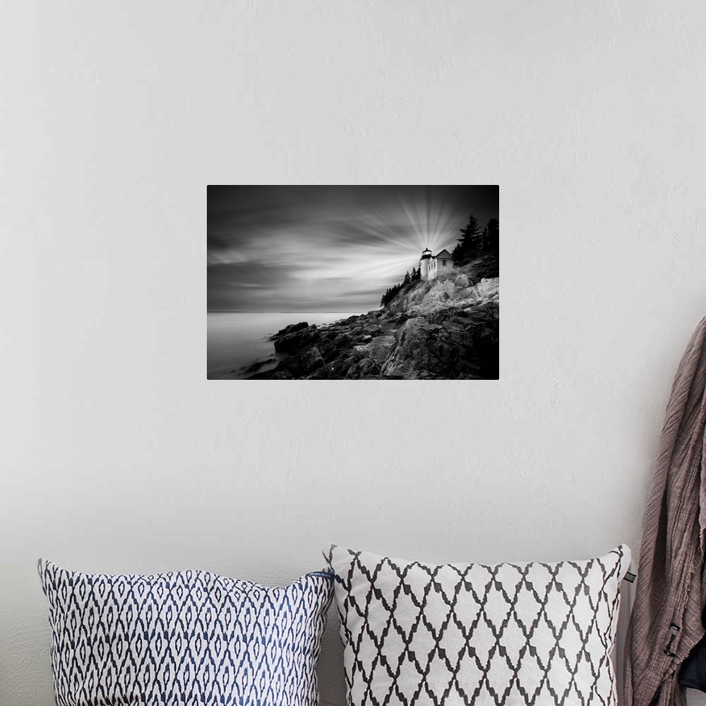 A bohemian room featuring A black and white photograph of a lighthouse on the coast of Maine.