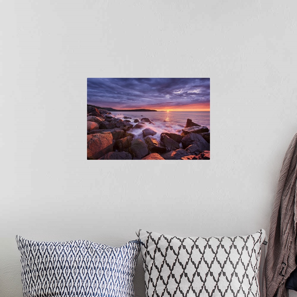 A bohemian room featuring Photograph of the coast of Acadia Maine with the sun setting under purple clouds in the distance.