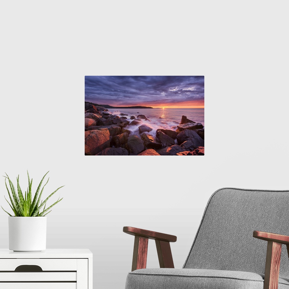 A modern room featuring Photograph of the coast of Acadia Maine with the sun setting under purple clouds in the distance.