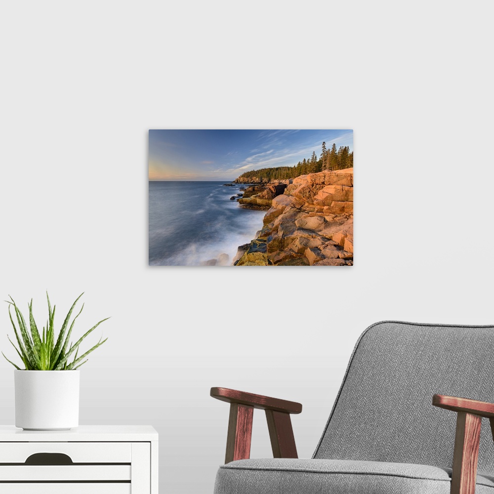 A modern room featuring A photograph of a rocky coastline in Maine.