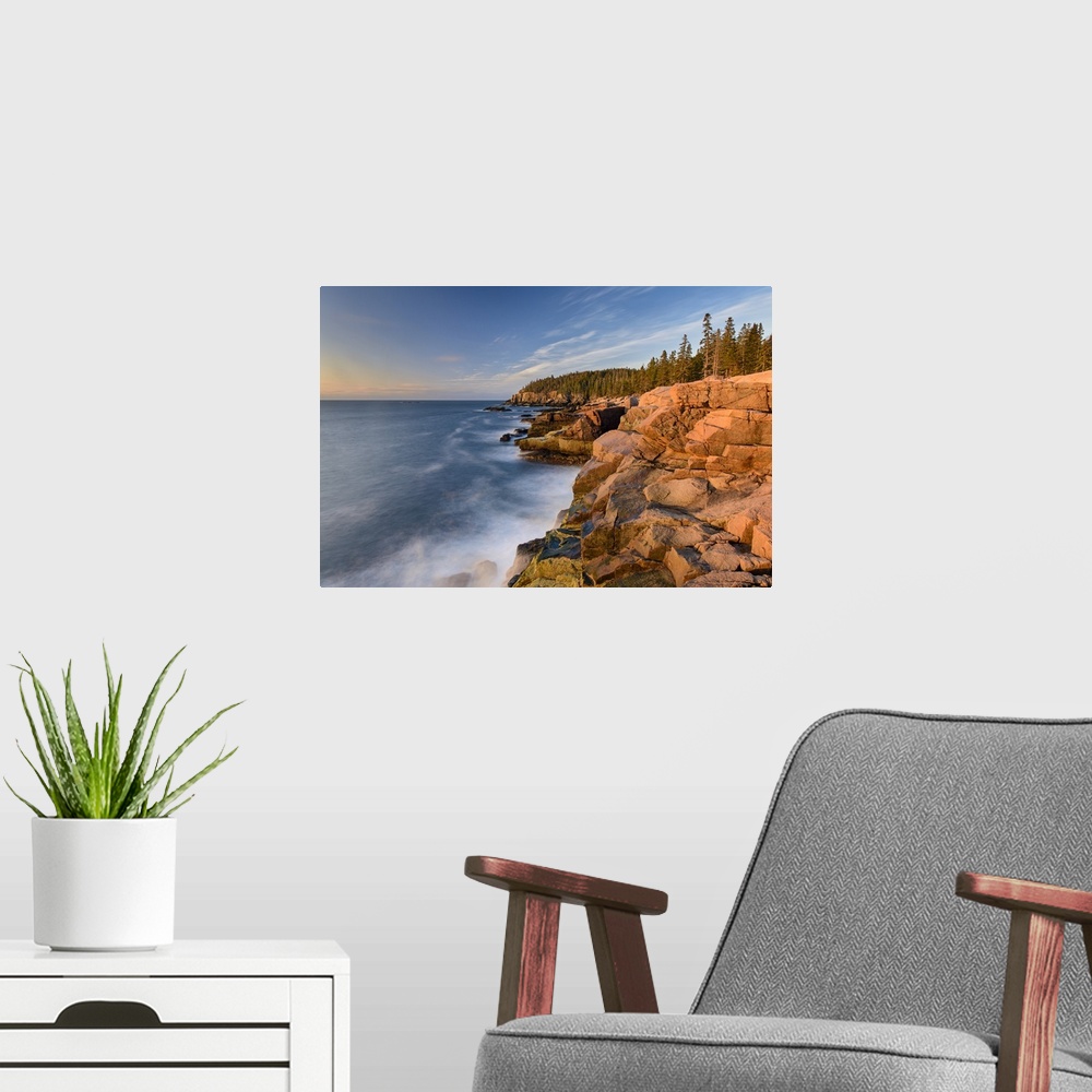 A modern room featuring A photograph of a rocky coastline in Maine.