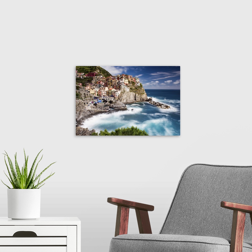 A modern room featuring A photograph of an Italian coastal village atop a cliff.