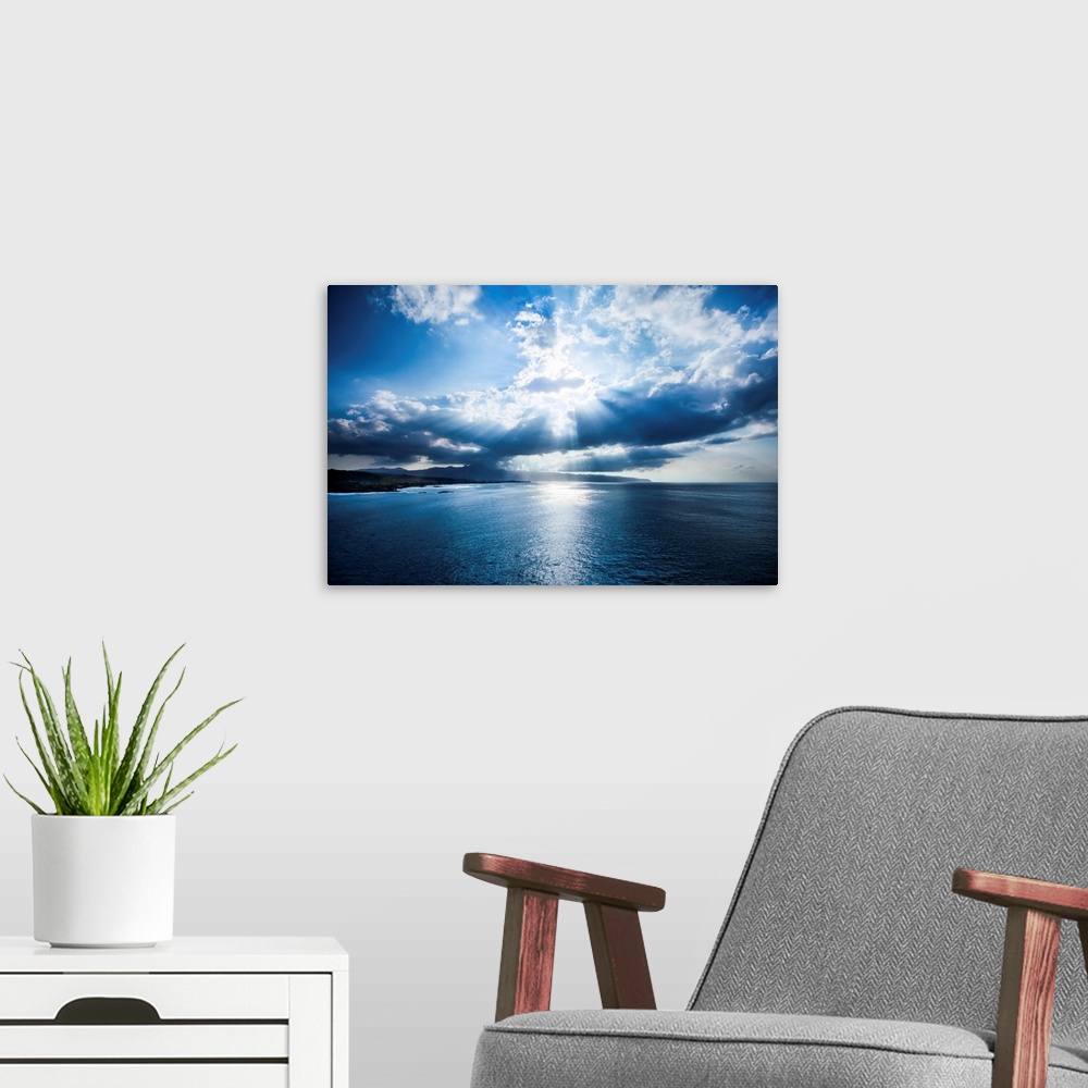 A modern room featuring An aerial photograph looking out over the Hawaiian seascape under intense clouds.