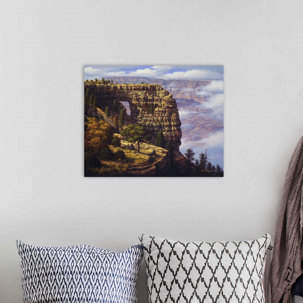 A bohemian room featuring Clouds trapped in mountains near a natural arch.