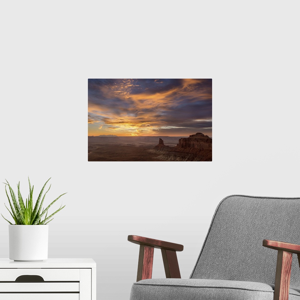 A modern room featuring A photograph of desert landscape illuminated by a warm sunset.