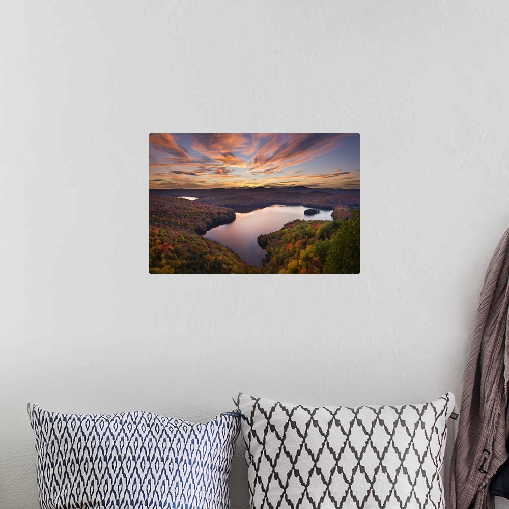 A bohemian room featuring A photograph of a wilderness landscape at sunset with a lake in the foreground.
