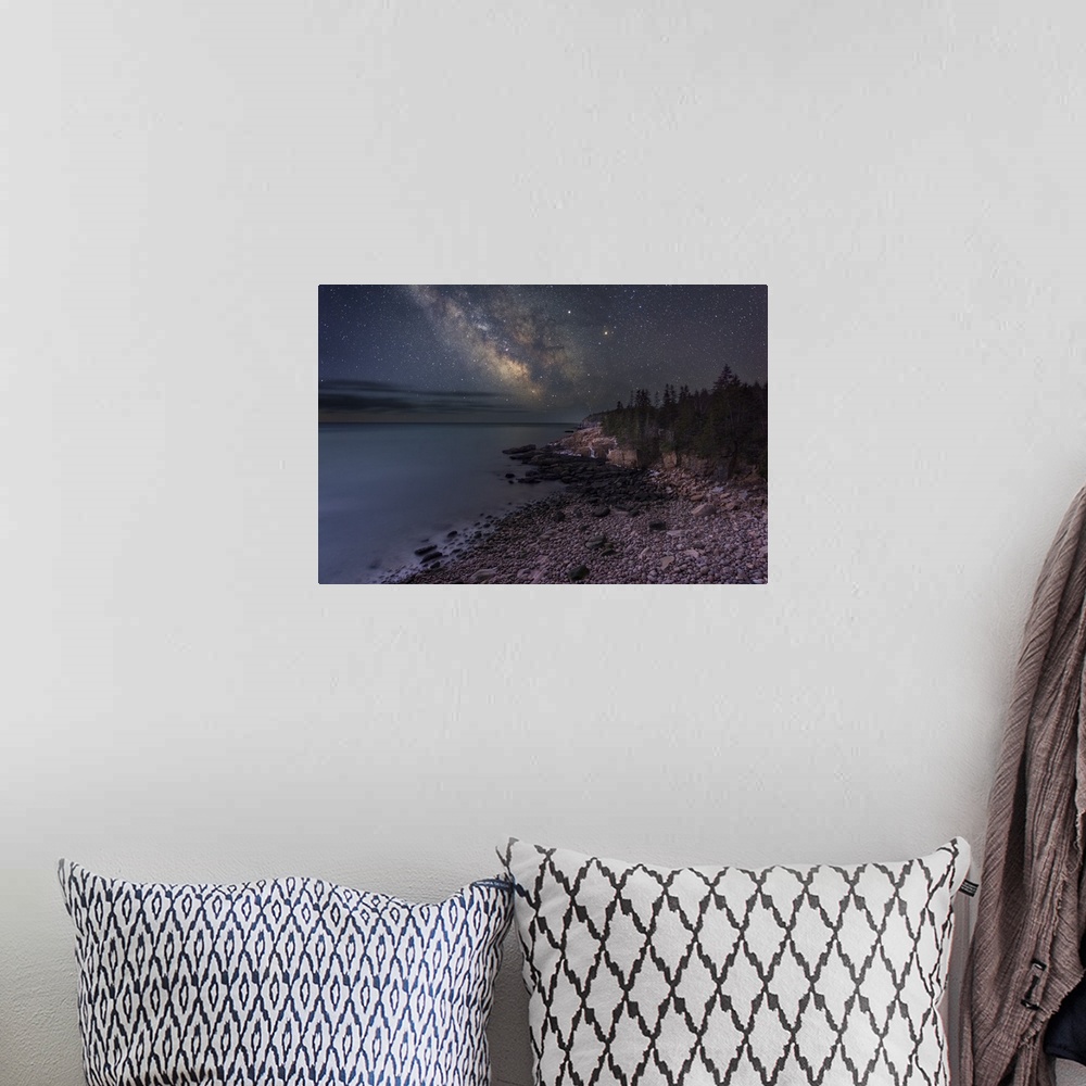 A bohemian room featuring A photograph of a rocky beach under a starry night sky.