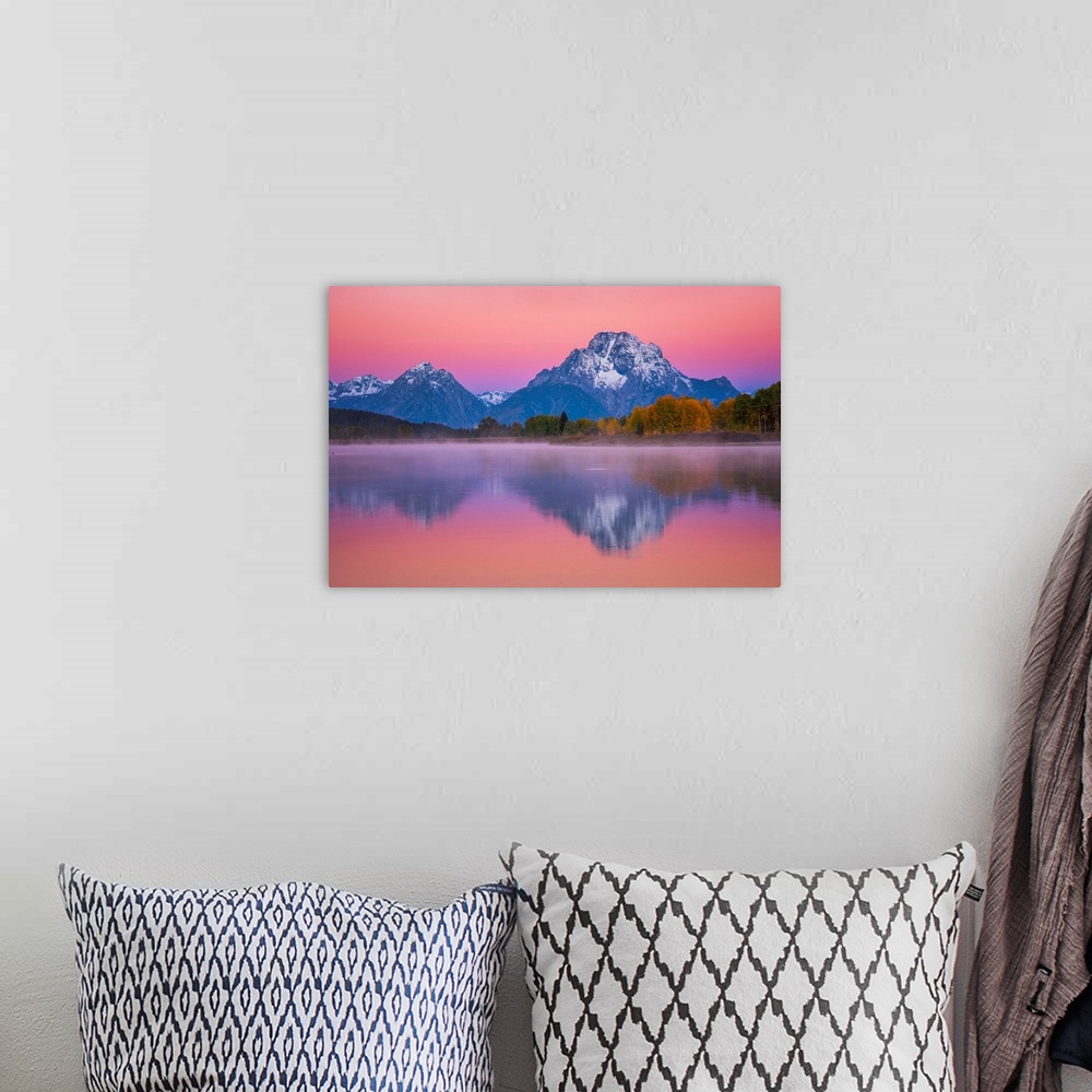 A bohemian room featuring Snow-capped mountains under a pink sunset sky reflected in a lake.