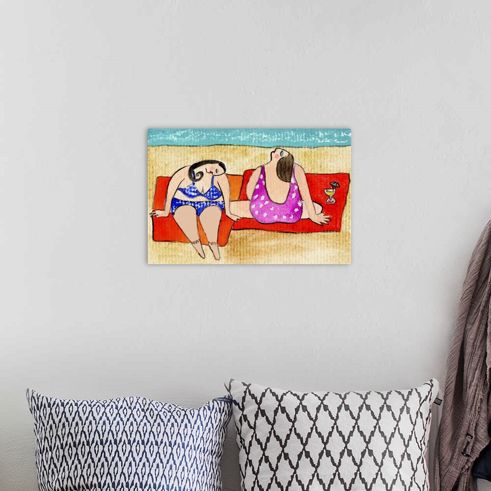 A bohemian room featuring Two women in swimsuits sitting near the ocean on red towels.