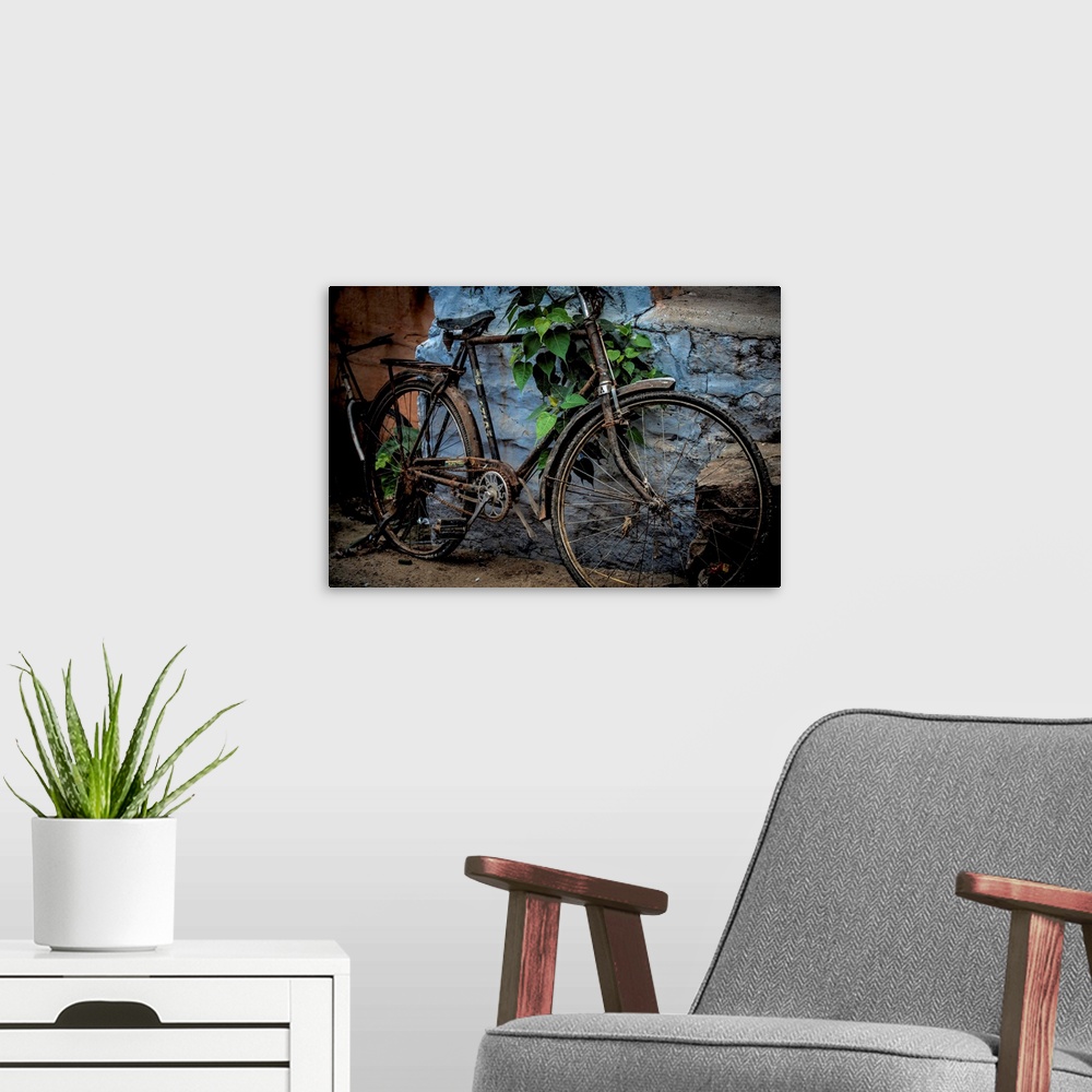 A modern room featuring Photograph of an old bicycle parked next to a bright blue wall.